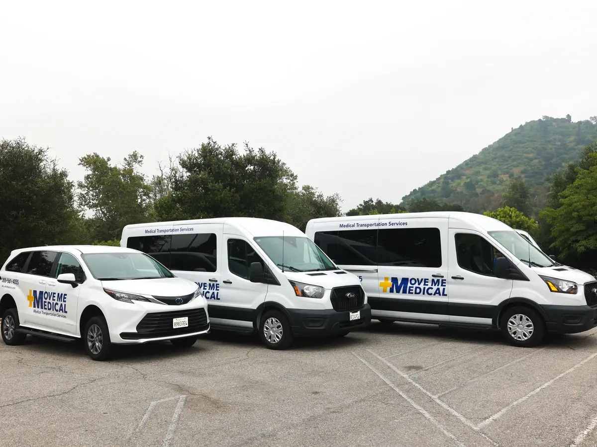 Three MoveMe Medical transport vehicles parked side by side
