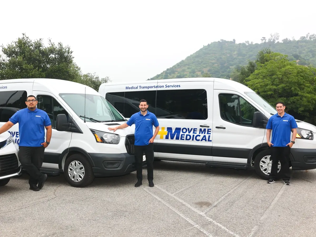 The MoveMe Medical team standing in front of their white transport vans